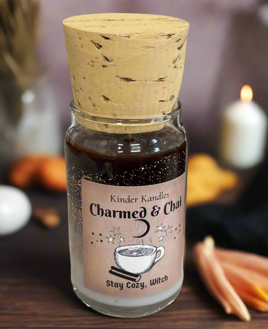 Bottle of 'Charmed & Co.' candle with cork lid on a textured surface